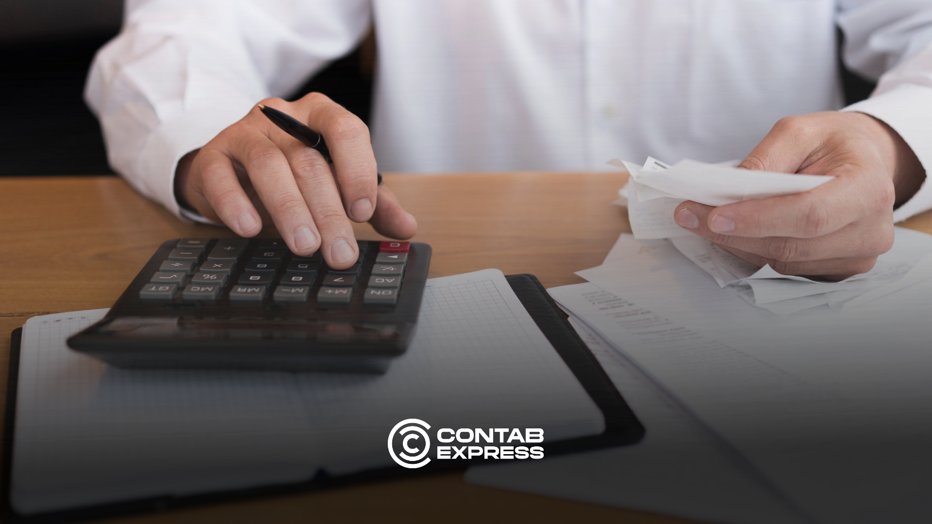 Contador revisa planilhas de simulação da CBS de 2027 no notebook, com calculadora e documentos sobre a mesa