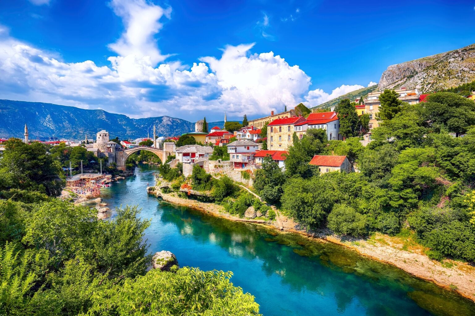 Fantastic Skyline of Mostar with the Mostar Bridge, houses and minarets, during sunny day. Location: Mostar, Old Town, Bosnia and Herzegovina, Europe