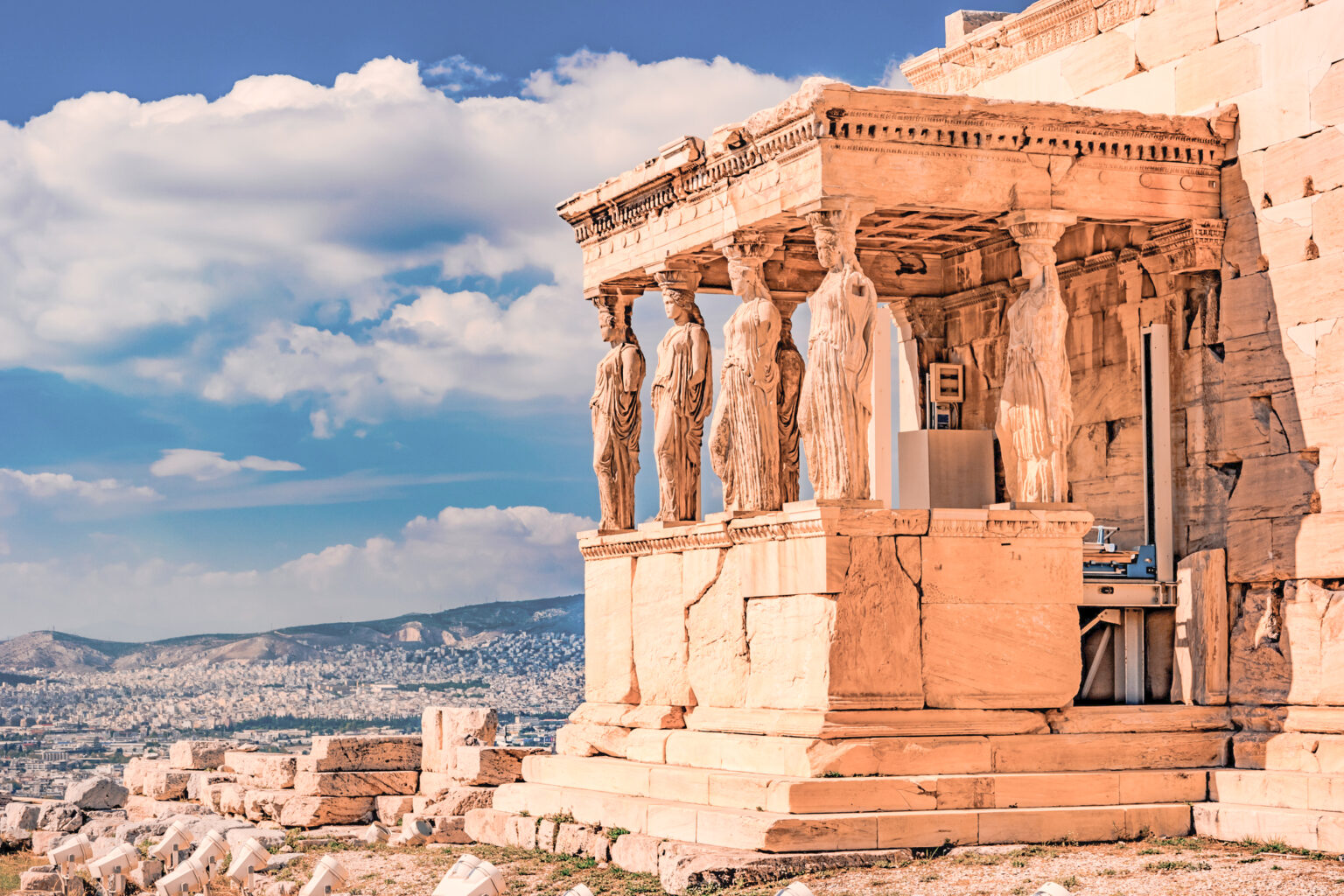 Stone porch with caryatids in Erechtheion temple in Acropolis, Athens in Greece with city view and sunset light selective focus