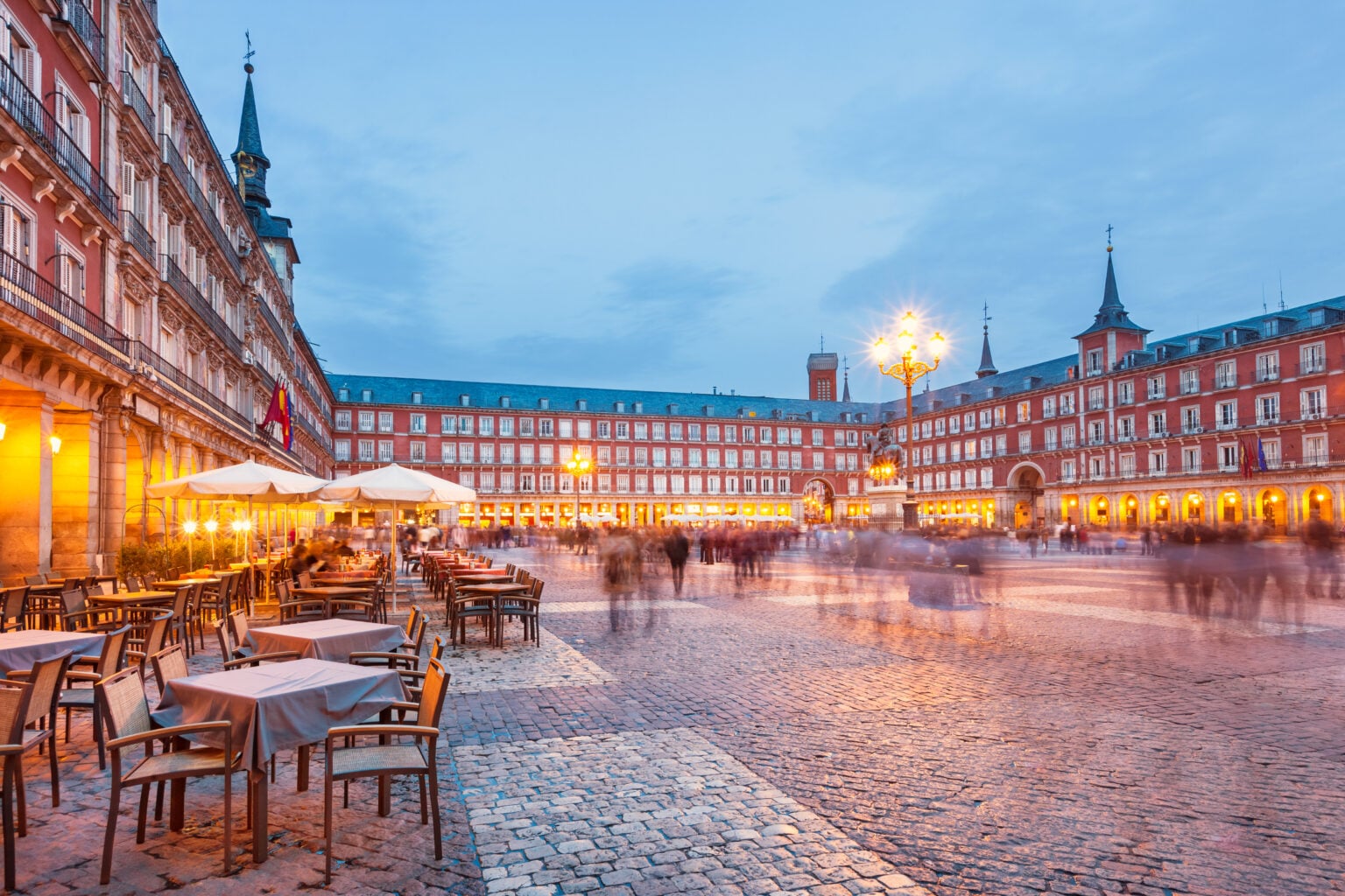 Stock photograph of Plaza Mayor, a large historic- square in central Madrid, Spain illuminated at twilight blue hour.