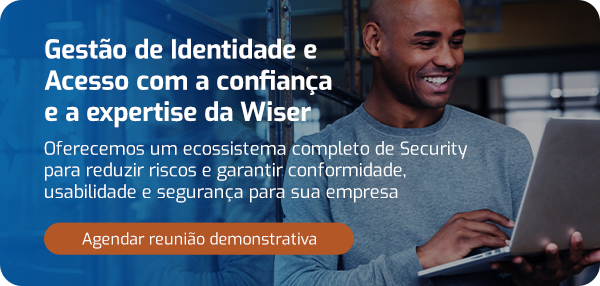Homem de negócios sorridente usando laptop, promovendo gestão de identidade e acesso confiável com expertise do Grupo Wiser para segurança empresarial.