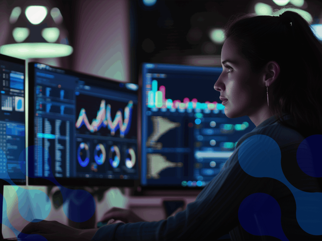 Pessoa analisando gráficos de desempenho em múltiplos monitores, focada em dados de RMM para gestão de sistemas e redes.